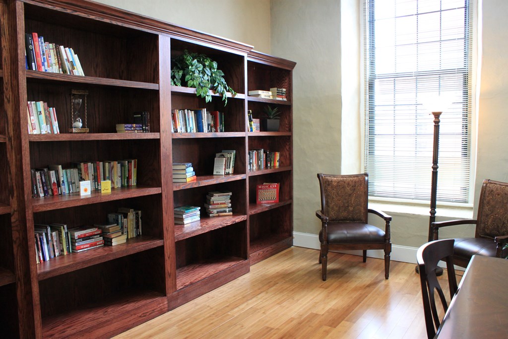a bookshelf in a room with chairs and a table