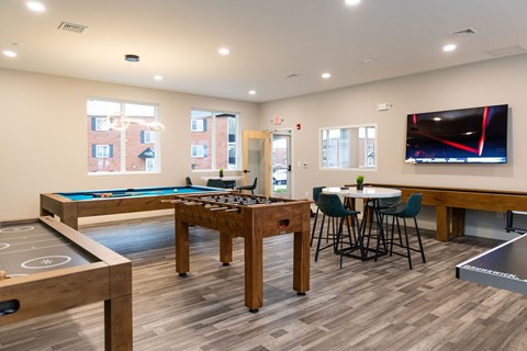A room with a pool table and a television.