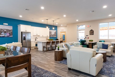 A spacious living room with a dining table and a kitchen area in the background.