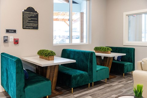 A white table with green chairs and a sign on the wall.