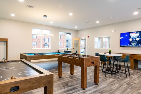 A room with a pool table and a TV.