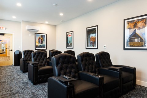 A row of black leather chairs are lined up in a room.