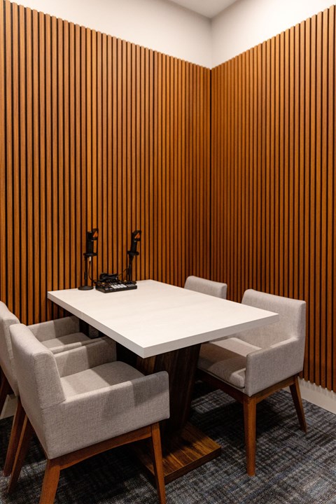 A conference room with a white table and four chairs.