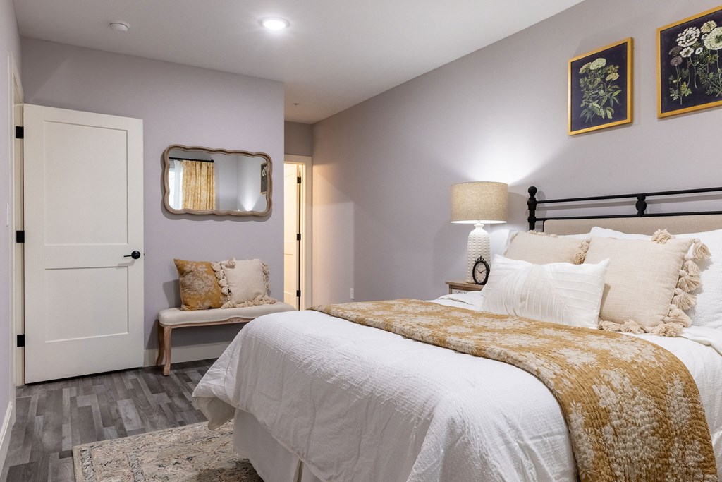 A bedroom with a large bed and a bench.