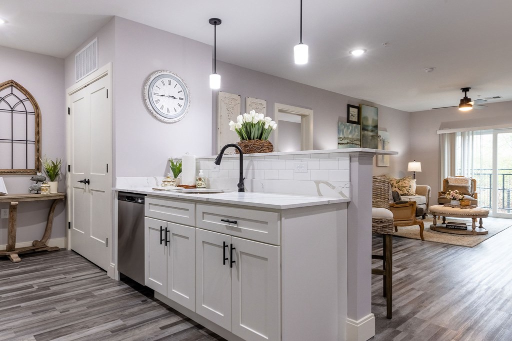 A modern kitchen with a large island and a clock on the wall.