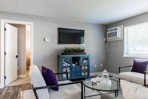 A living room with a blue cabinet, a white couch, and a glass table.