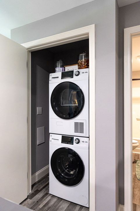 A white front loading washing machine in a small laundry room.