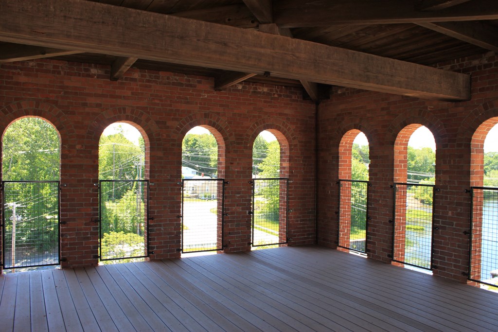 an open room with windows and a wooden deck