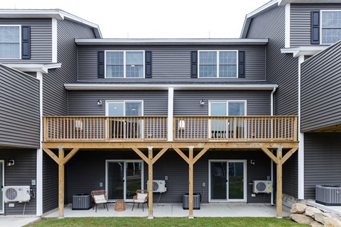 A grey house with a wooden balcony.