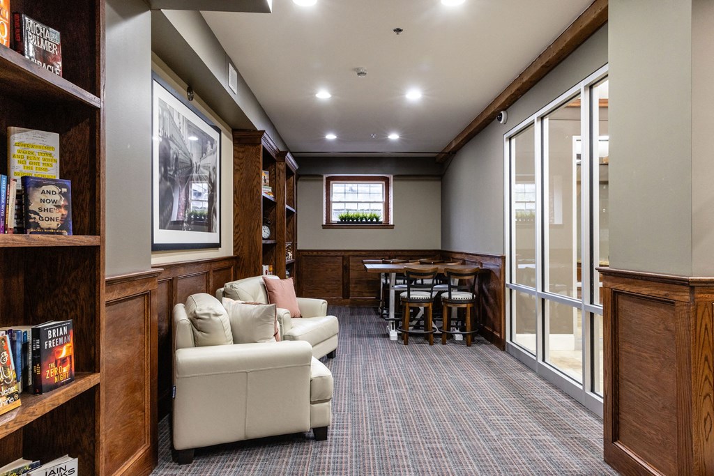 A room with a couch, chairs, and a bookshelf.