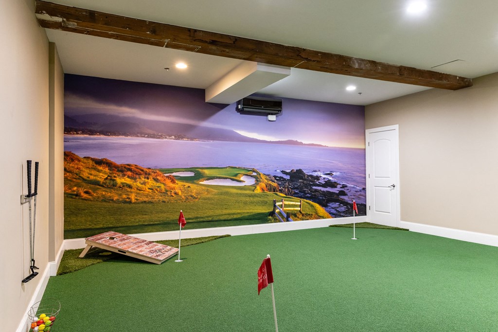 A room with a golf themed wallpaper and a putting green.