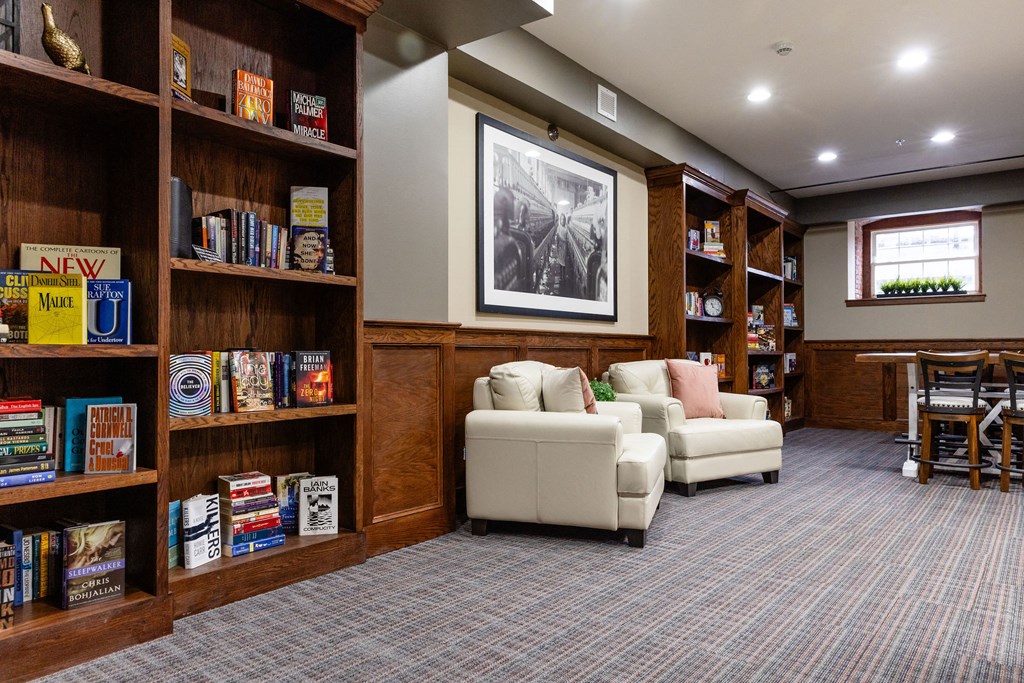 A room with a bookshelf filled with books and a couch.