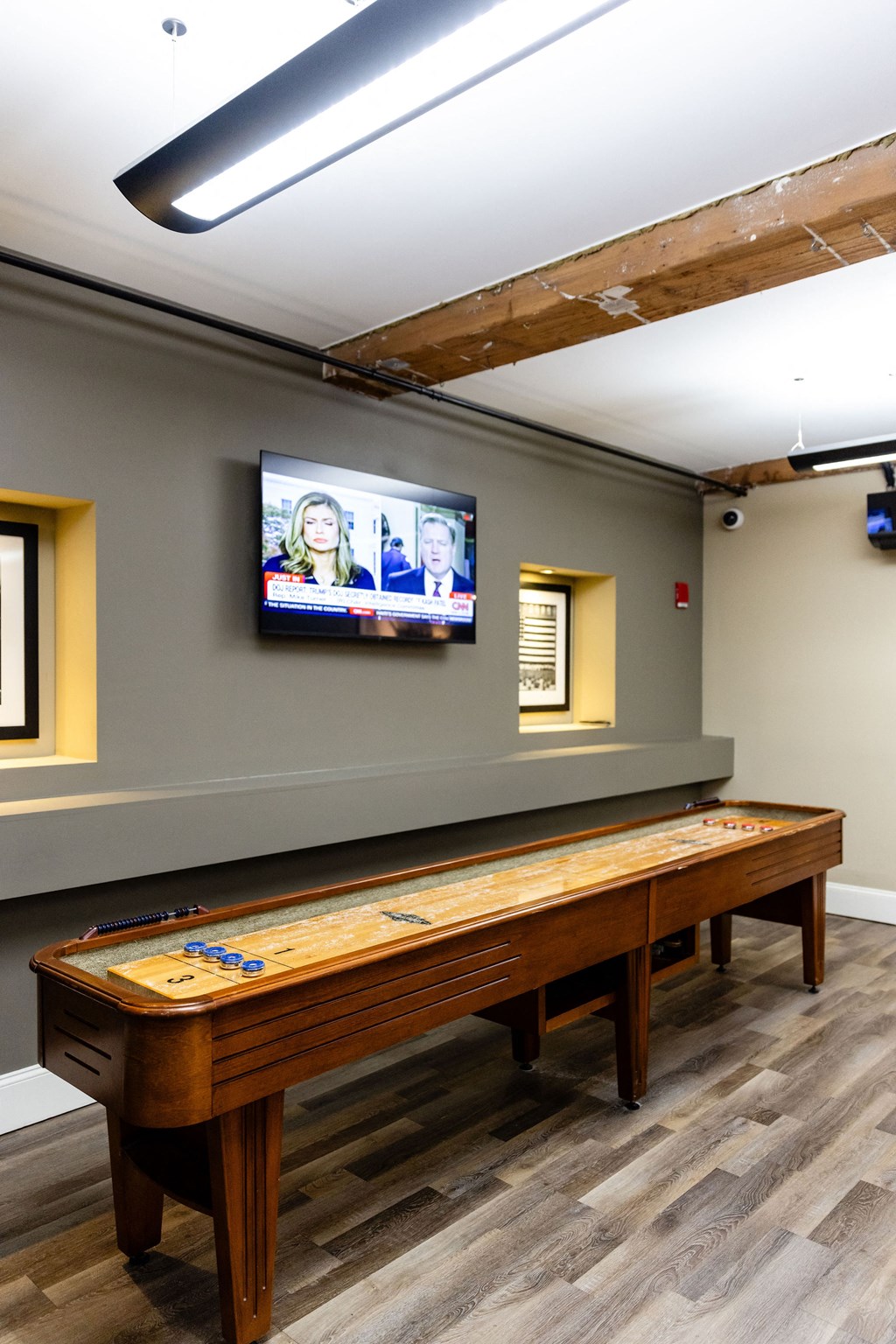 A long table with a pool table in the middle and a television mounted on the wall.