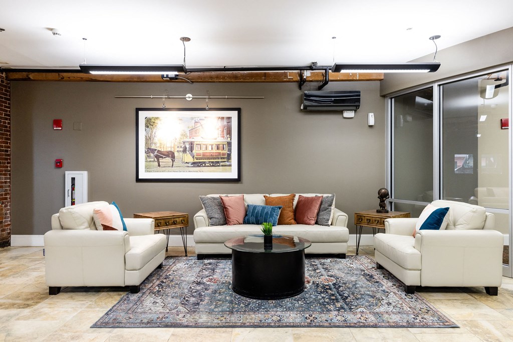 A living room with a large painting on the wall and a coffee table in the center.