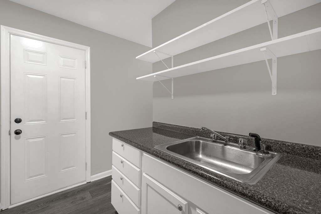 A kitchen with a sink and a door.