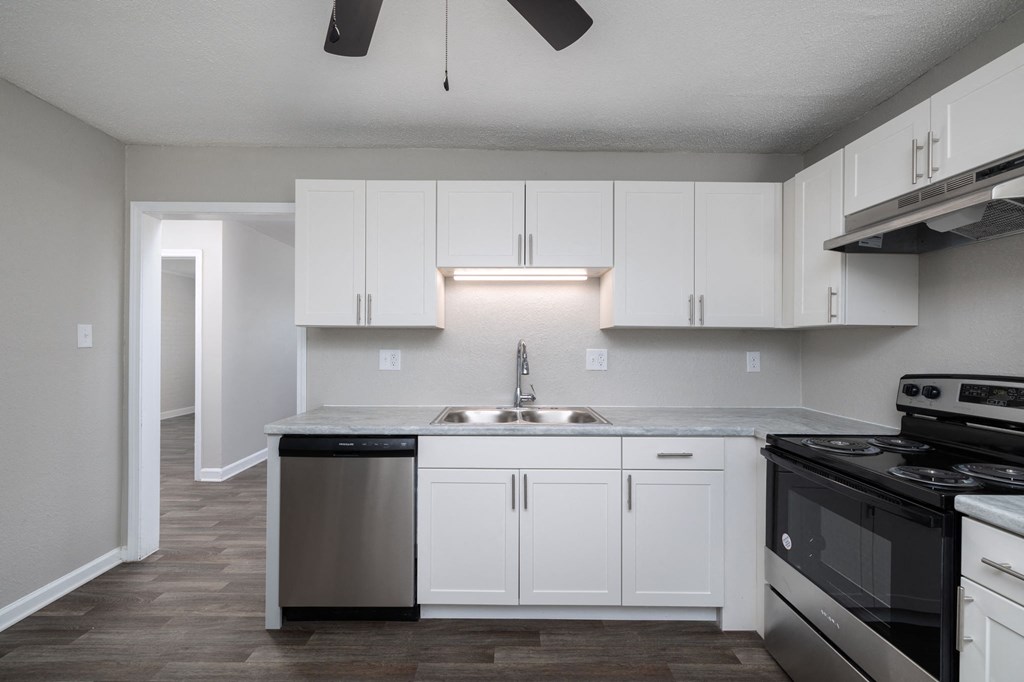an empty kitchen with white cabinets and stainless steel appliances