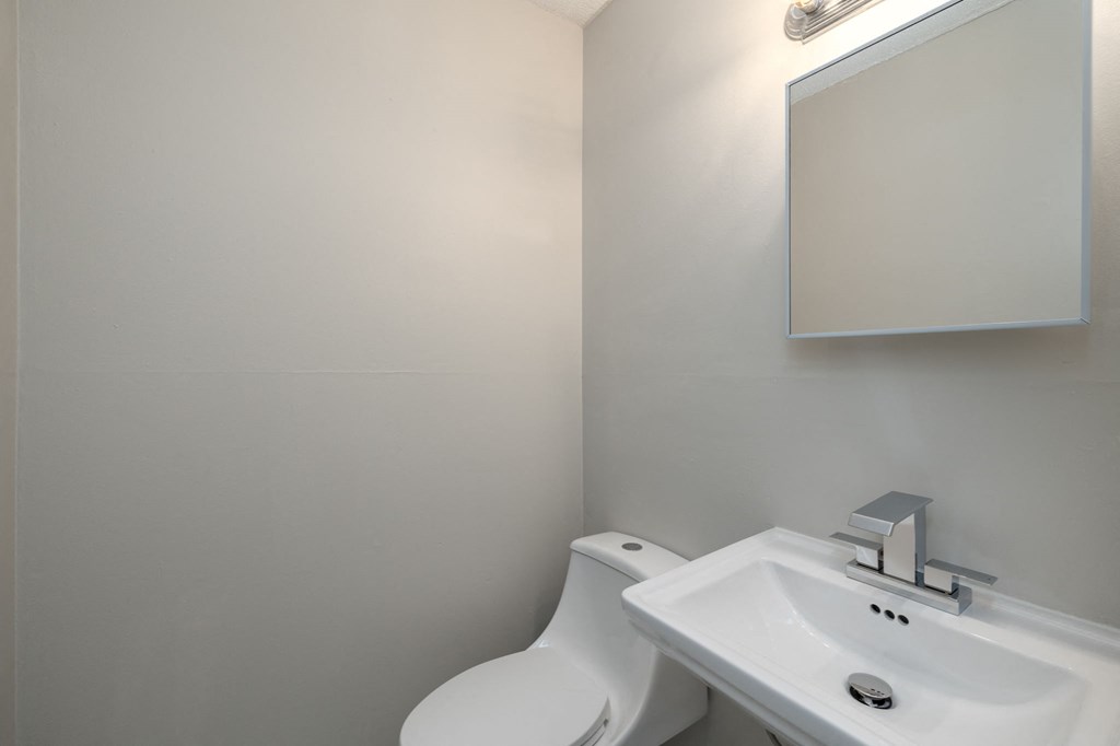 a small bathroom with a sink toilet and mirror