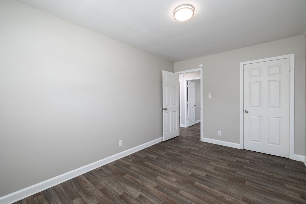 an empty living room with wood flooring and a white door