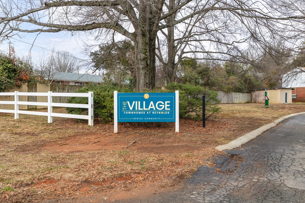 a sign for the village at the side of a road
