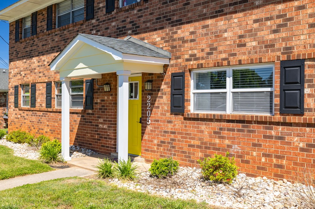 a small porch in front of a brick building