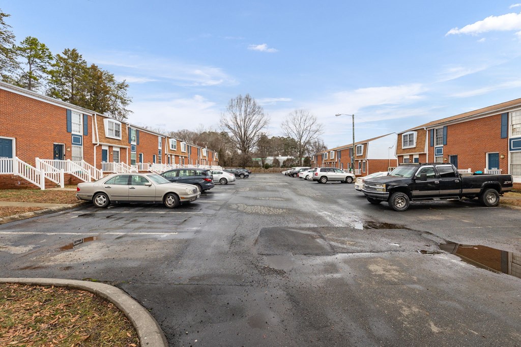 a parking lot with cars in front of apartment buildings