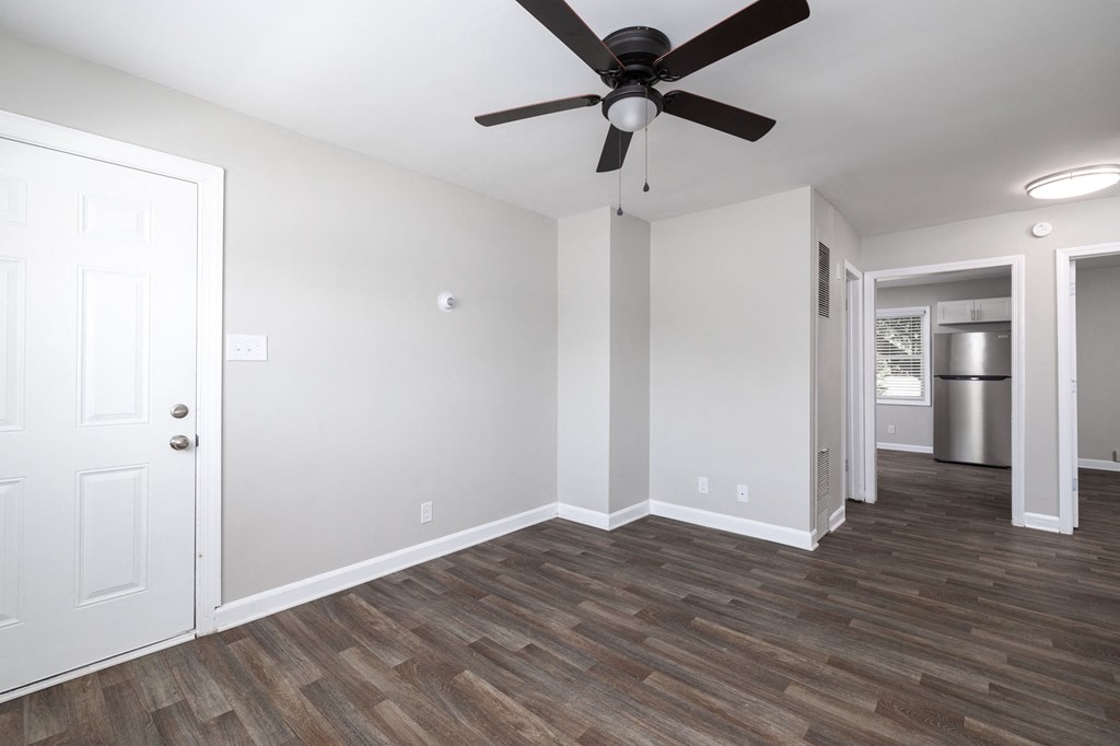 a living room with white walls and a ceiling fan