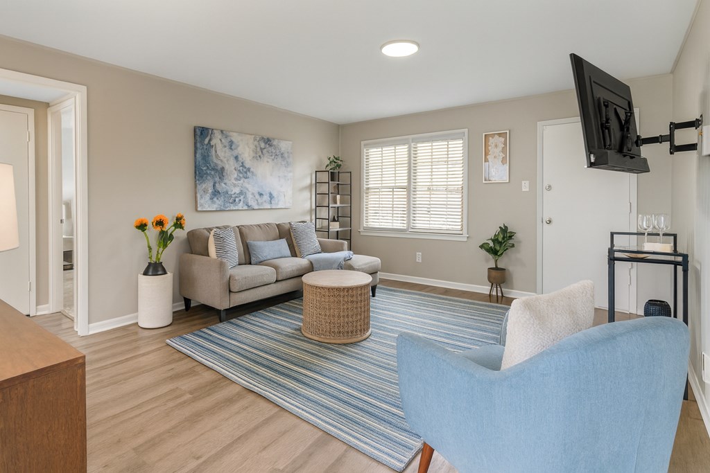 A living room with a blue chair and a television.