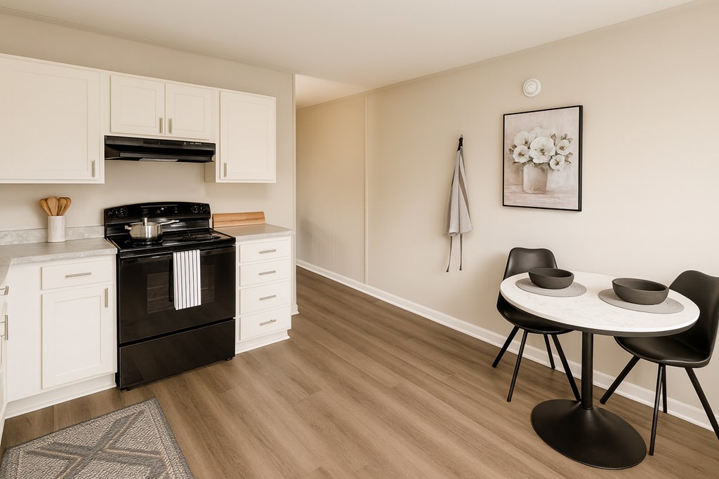 A modern kitchen with a black stove top oven and white cabinets.