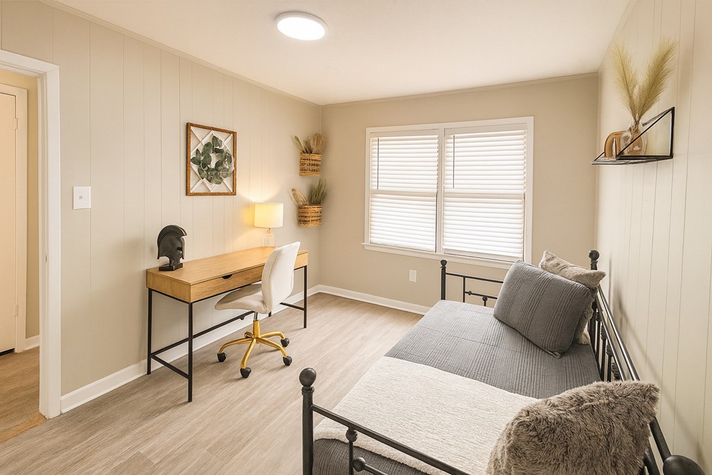 A bedroom with a bed, desk, and chair.