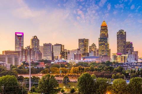 A city skyline at sunset with a prominent building in the center.