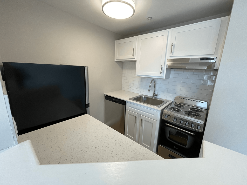 A kitchen with a black screen on the wall.