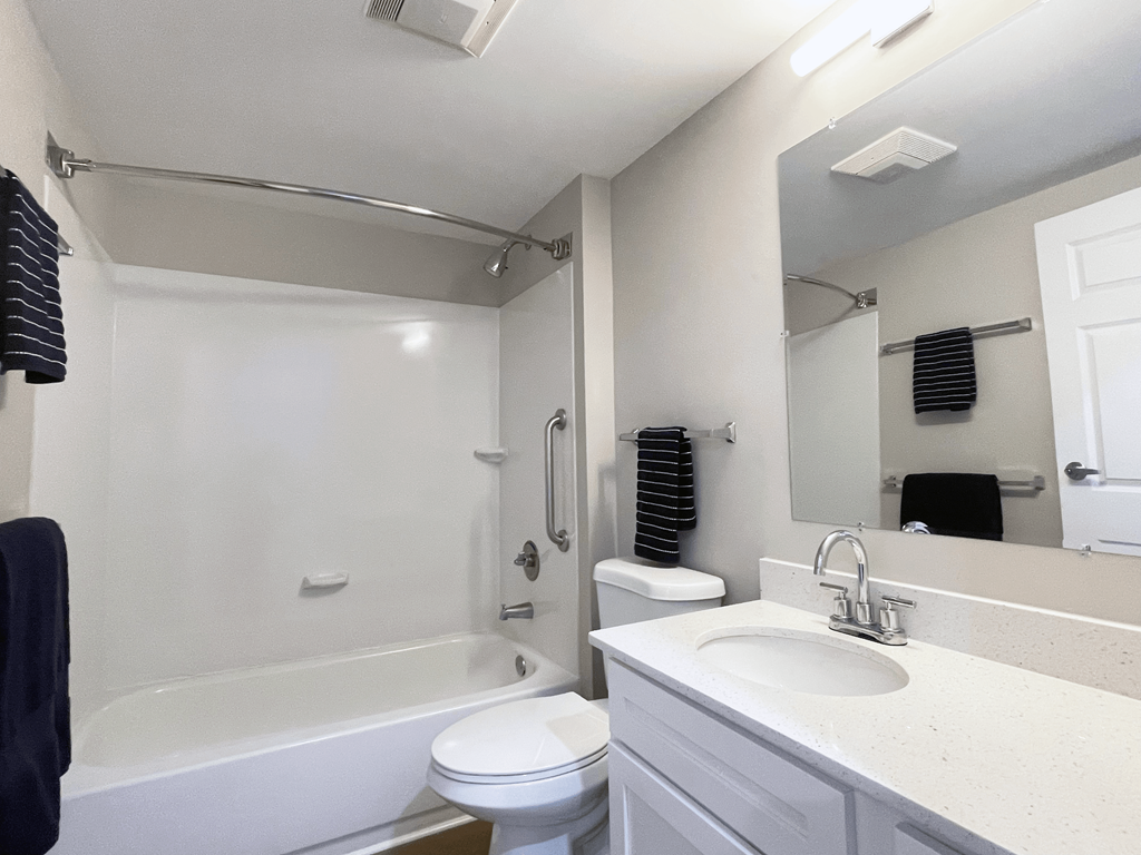 A white bathroom with a toilet, sink, and bathtub.