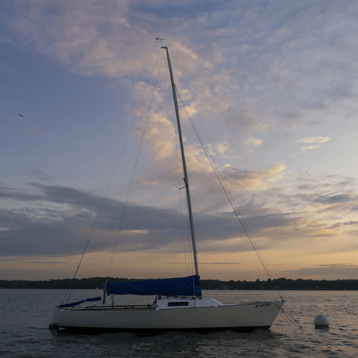 a sailboat on the water at sunset