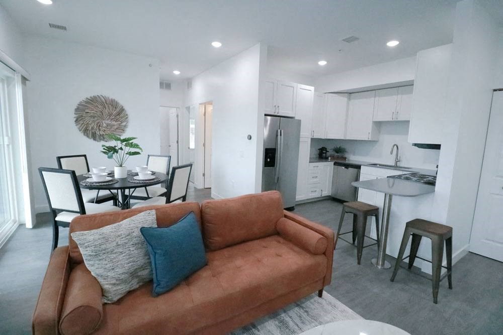 a living room and kitchen with a couch and a table