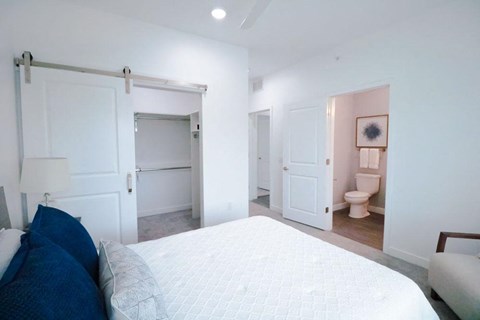 a bedroom with a bed and a bathroom with a toilet