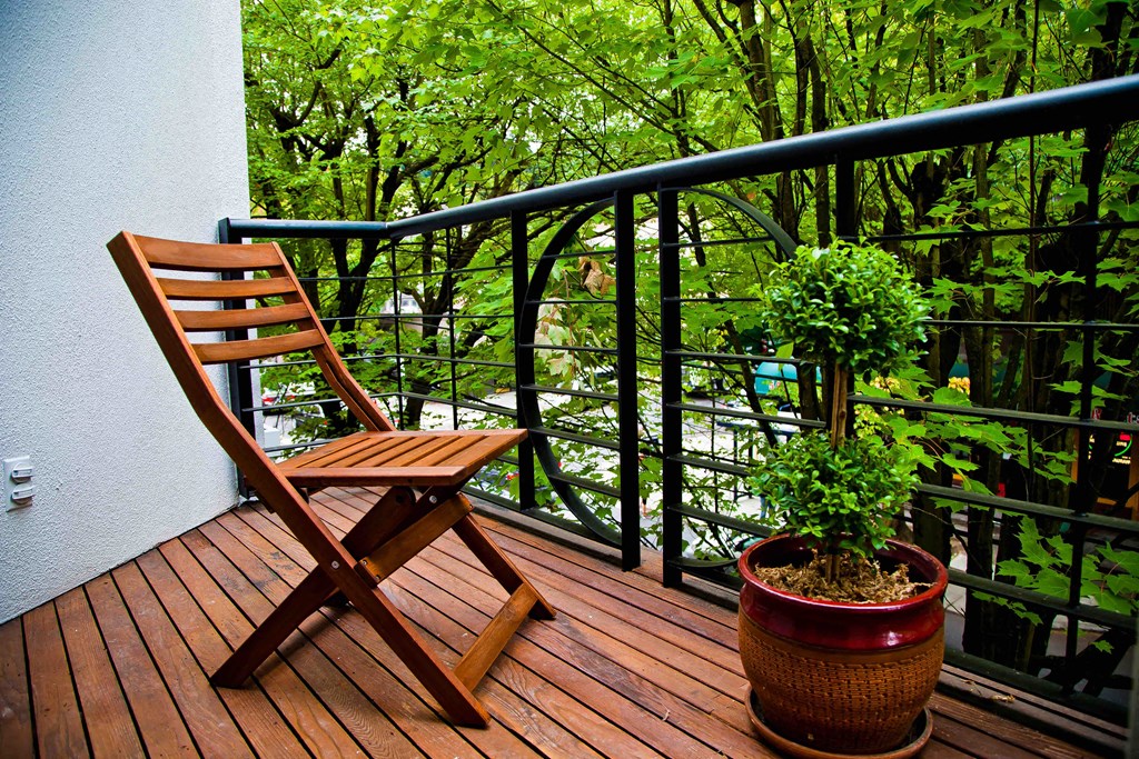 a wooden chair and a potted plant on a balcony