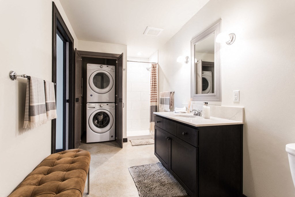 a bathroom with a sink and a washing machine in it