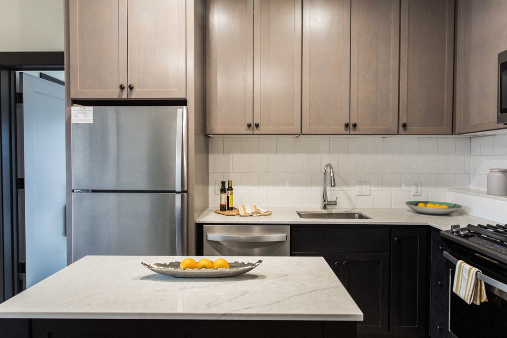 a kitchen counter with a bowl of oranges on it