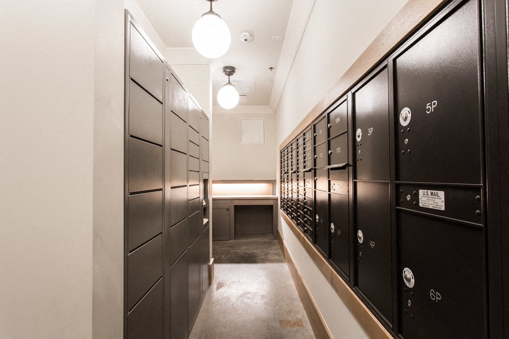 a long hallway with black lockers and white walls