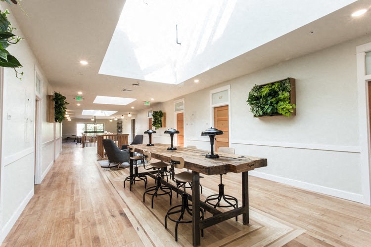 a long dining room with a wooden table and chairs