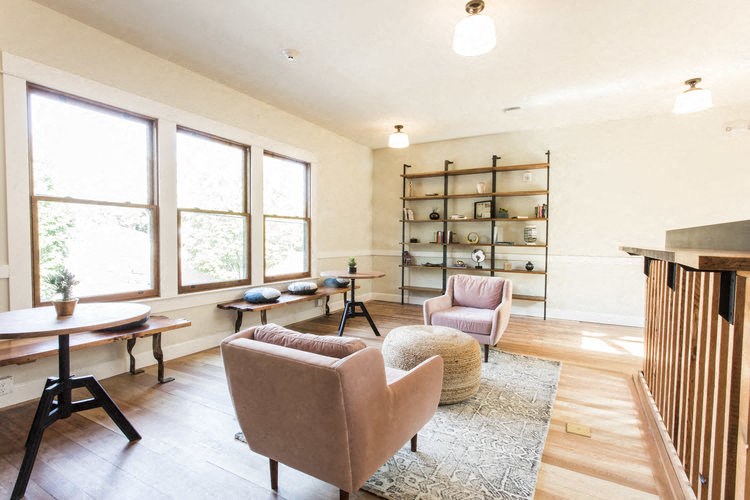 a living room with chairs and a table and a fireplace
