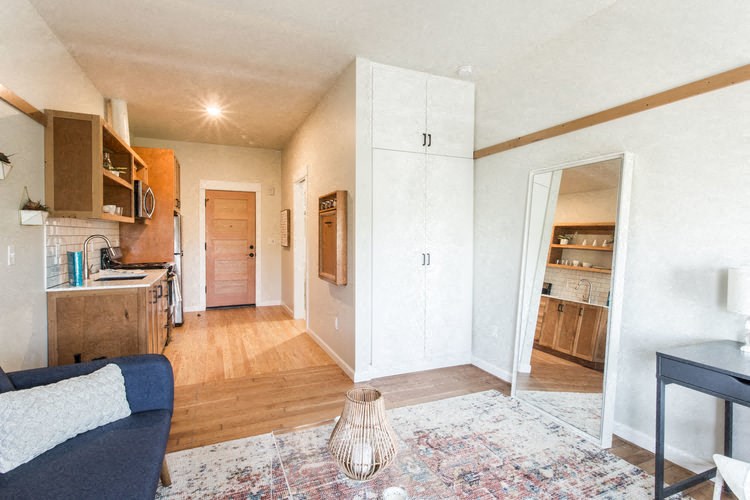 the living room and kitchen of a renovated apartment