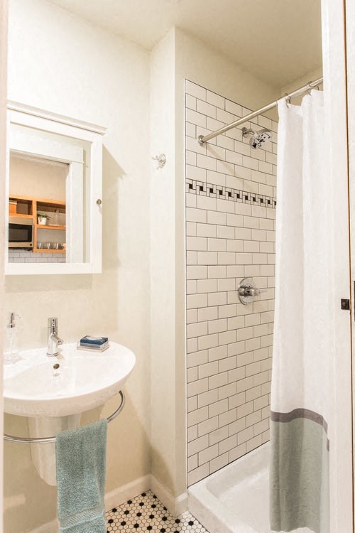 a white bathroom with a sink and a shower