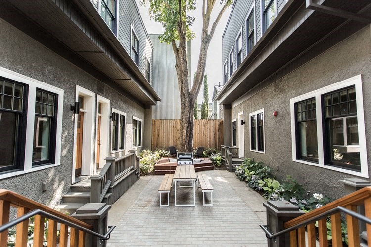 a courtyard with tables and benches outside of a building