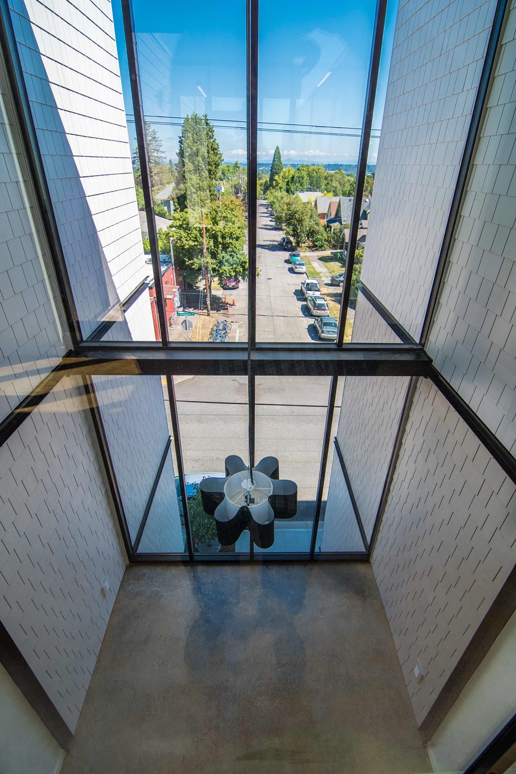 a view from the inside of a glass elevator with a flower on the floor