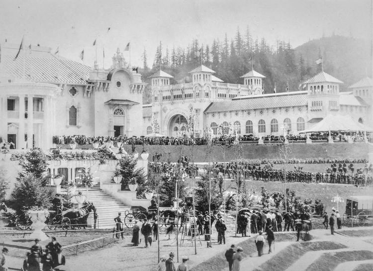 a crowd of people standing in front of a large building