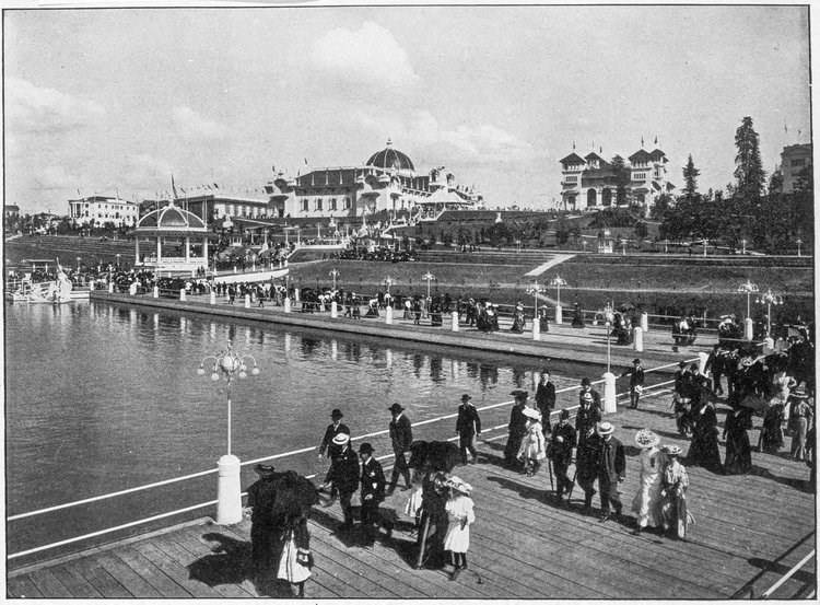 a group of people standing on a dock near a body of water