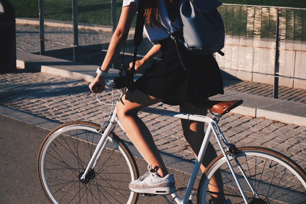 a woman riding a bike down a street