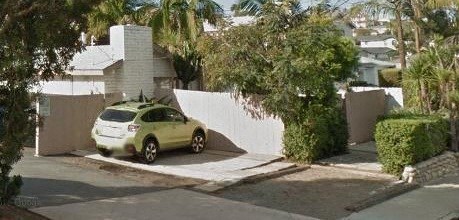 a yellow car parked in front of a white wall