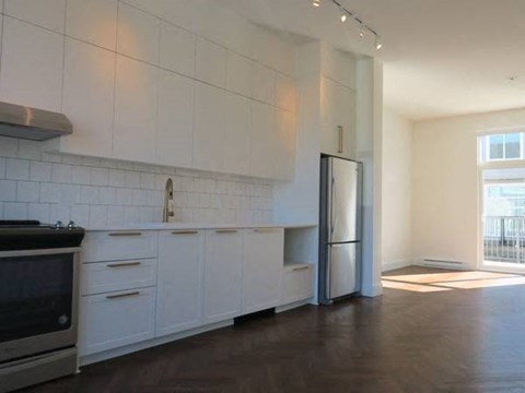 A kitchen with white cabinets and a black stove top oven.